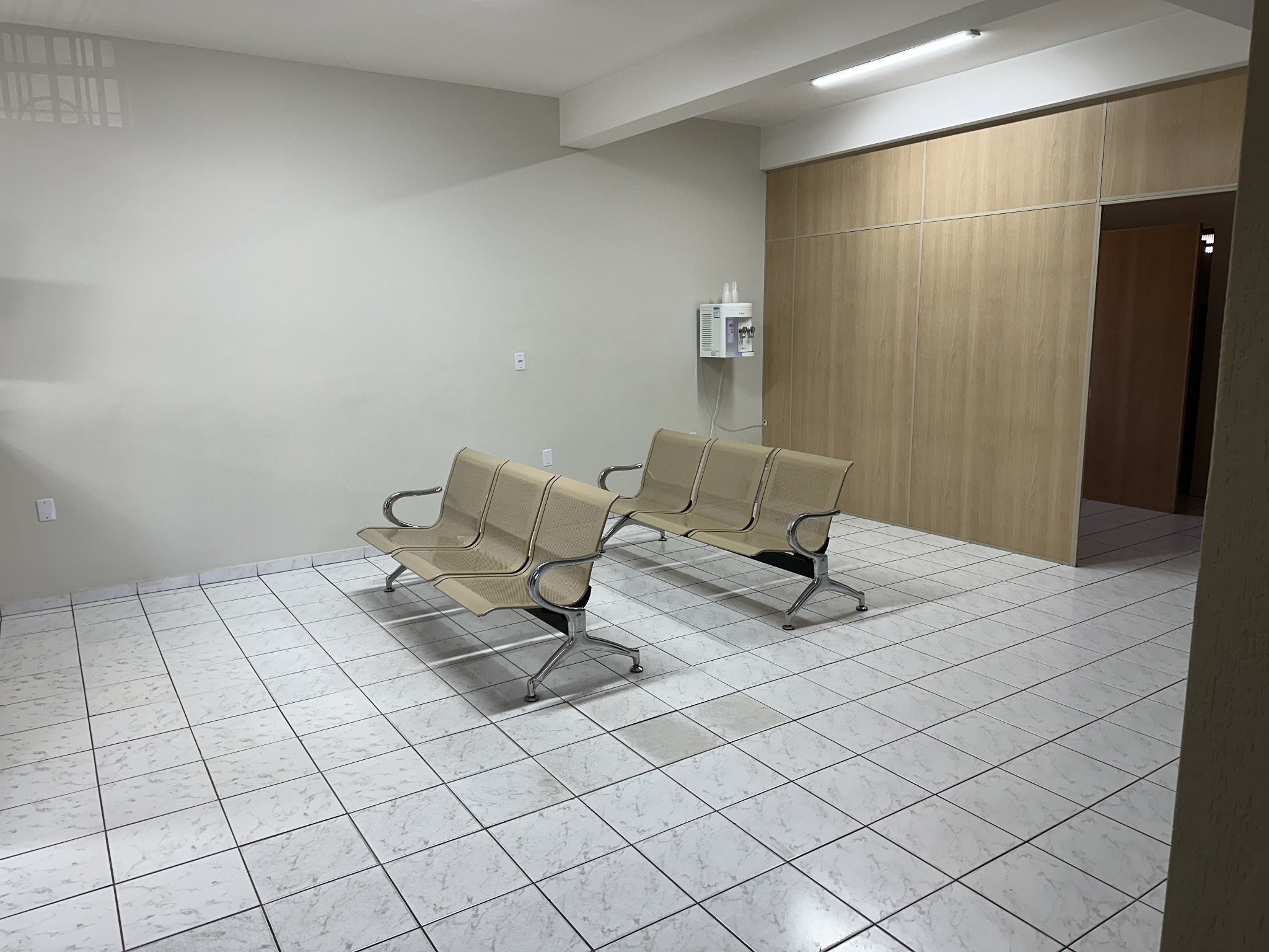 Sala de espera do Despachante De Marco, com assentos e divisórias amadeiradas.